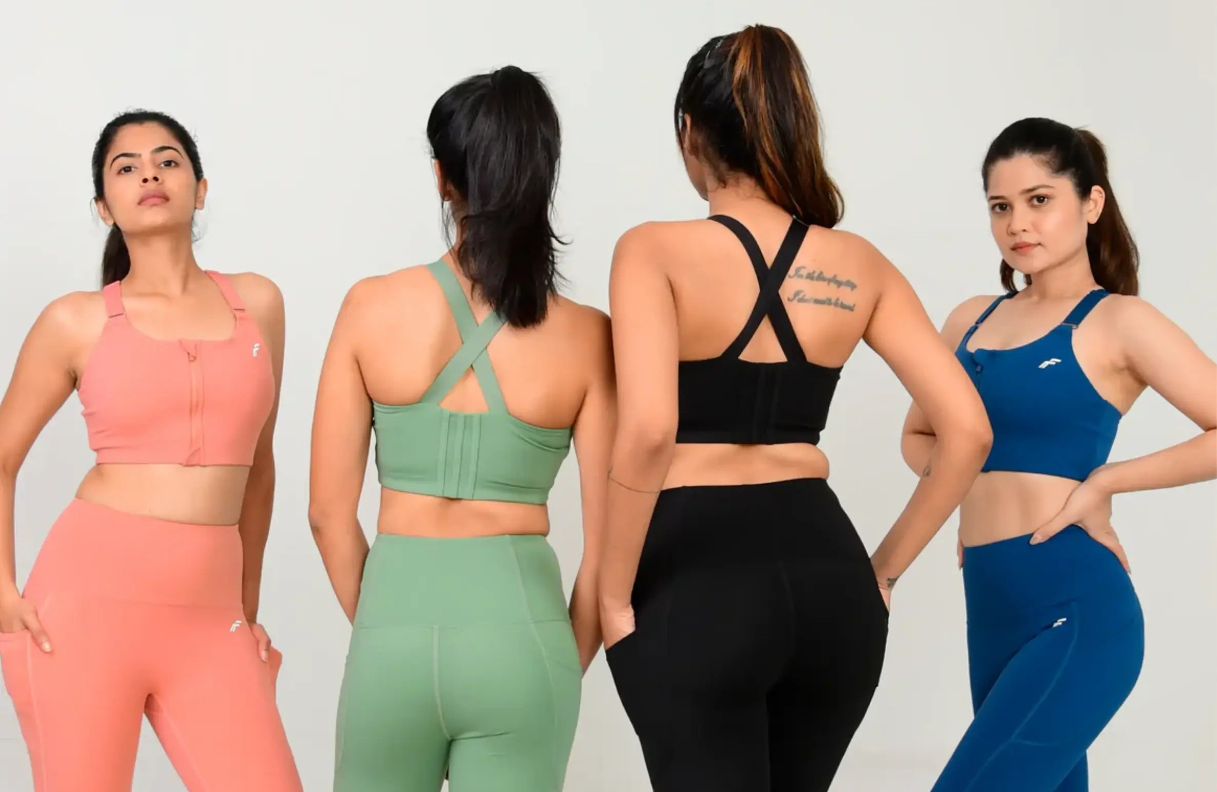Four women showcasing supportive sports bras for full bust in different colors and back styles, highlighting comfort, fit, and coverage